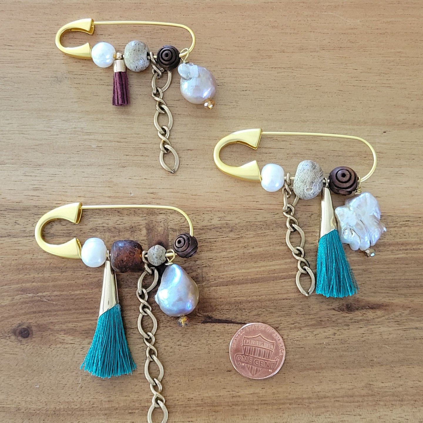 gold safety pin w variety of charms and freshwater pearls