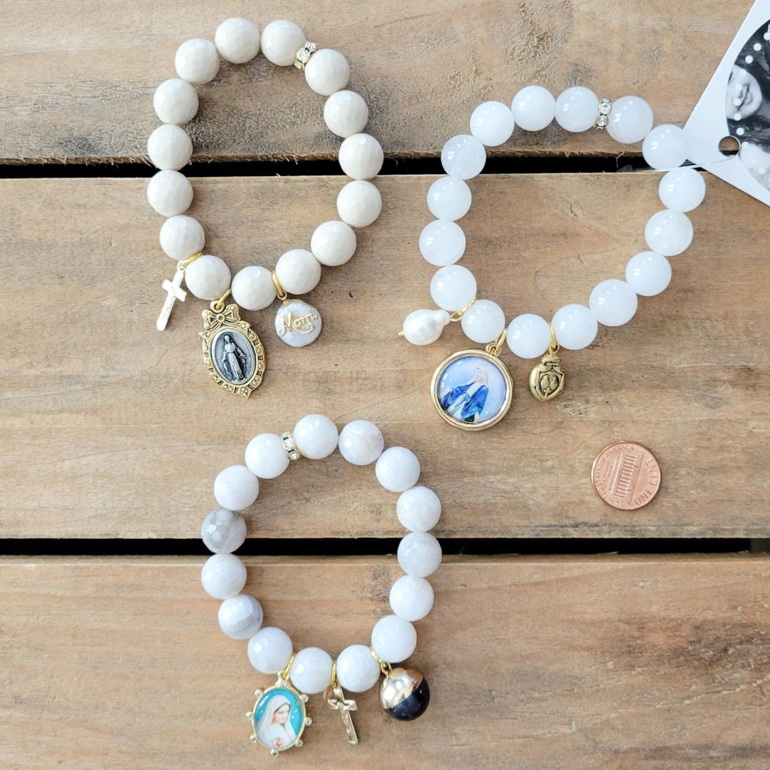 variety of bead bracelets each with 3 charms / medals
