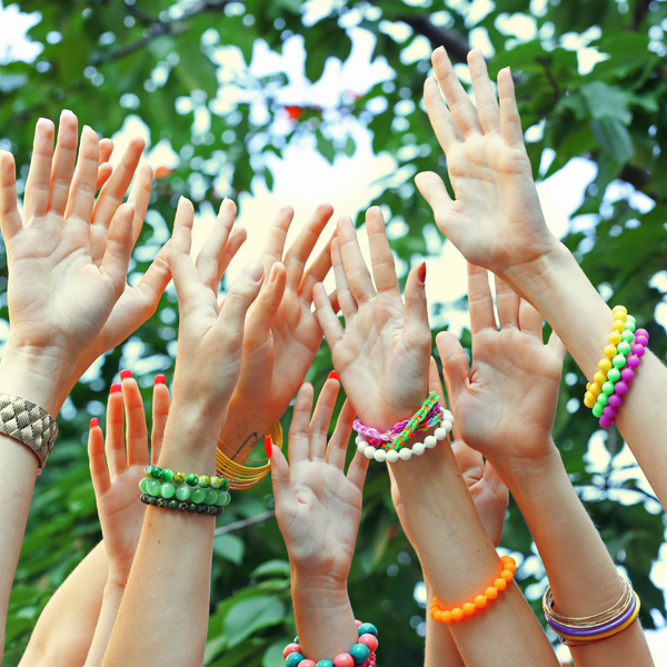 Hands in the air wearing stretch bead bracelets