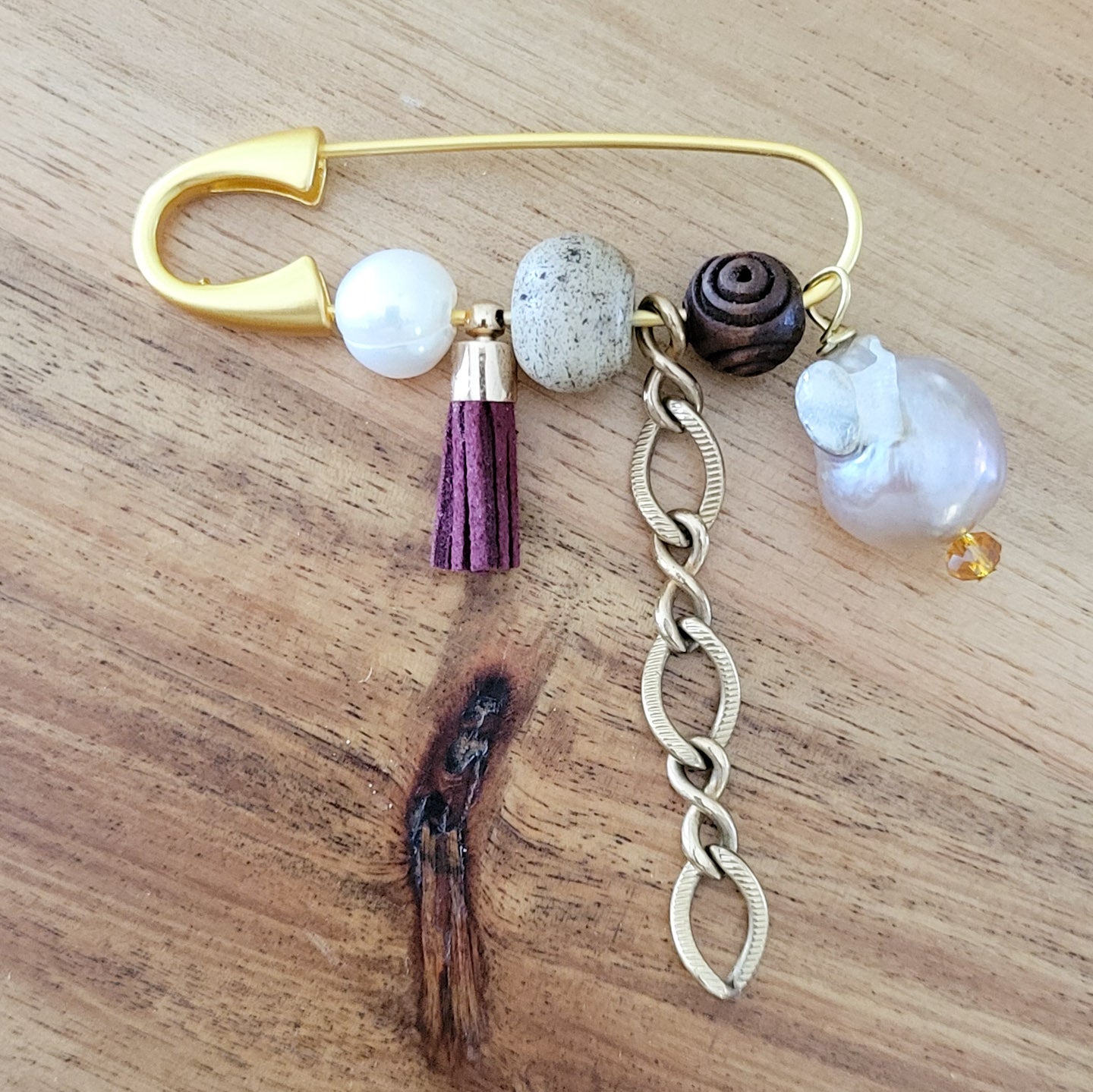 gold safety pin w variety of charms and freshwater pearls