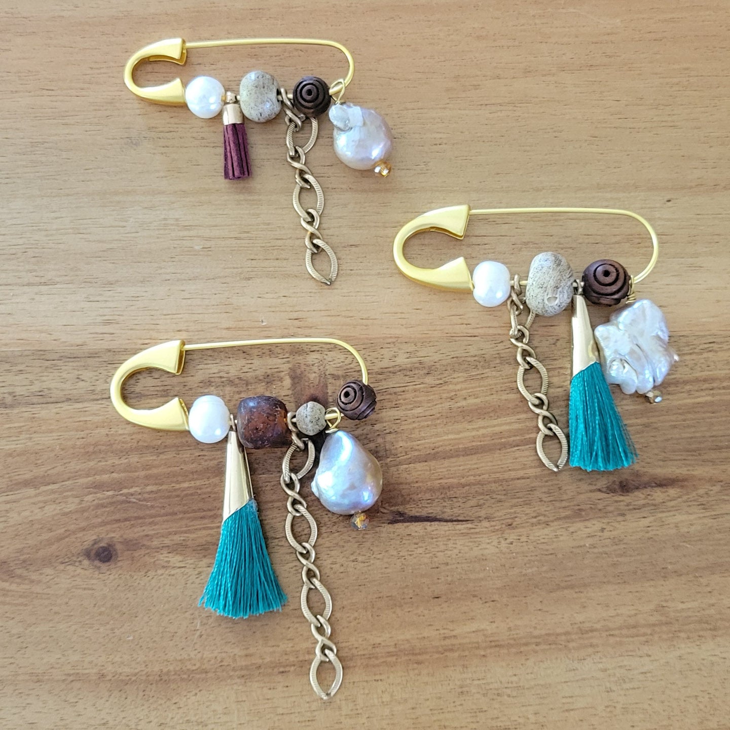 gold safety pins w variety of charms and freshwater pearls