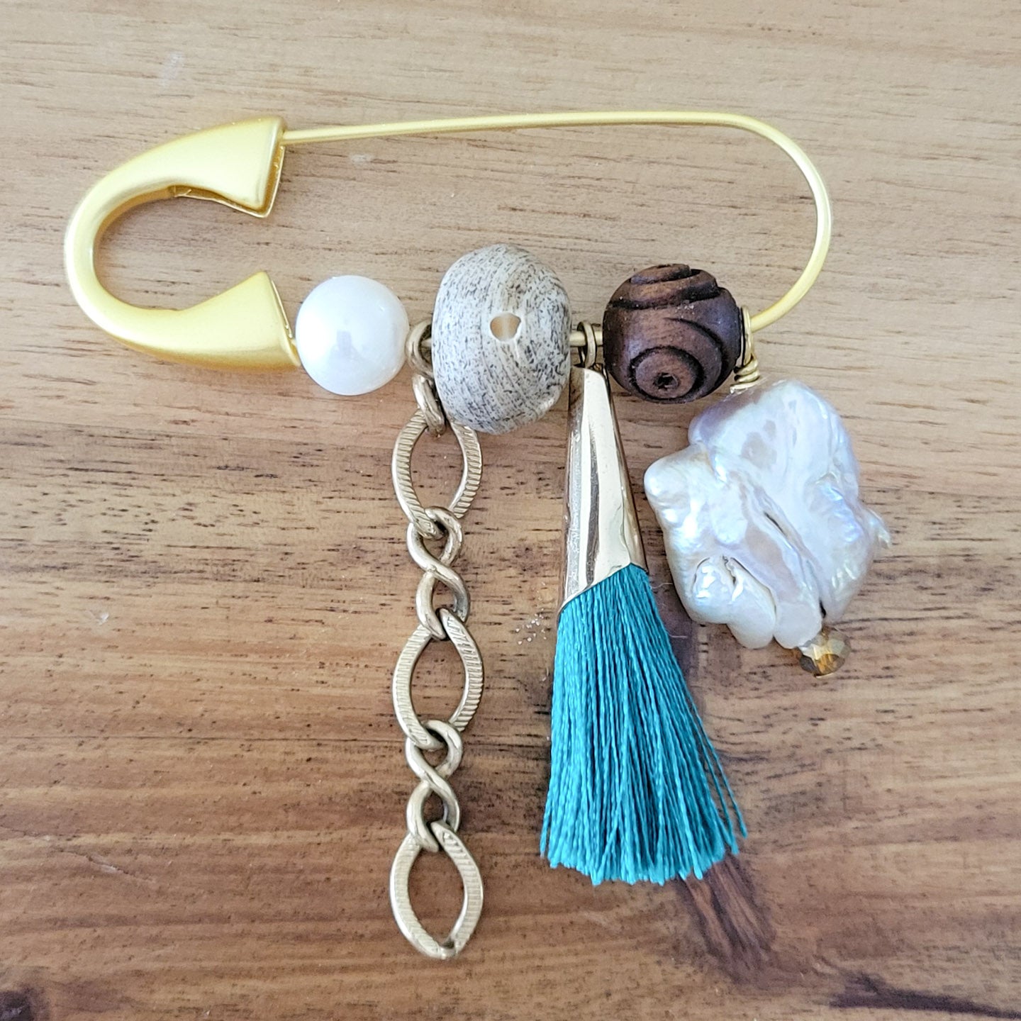 gold safety pin w variety of charms and freshwater pearls