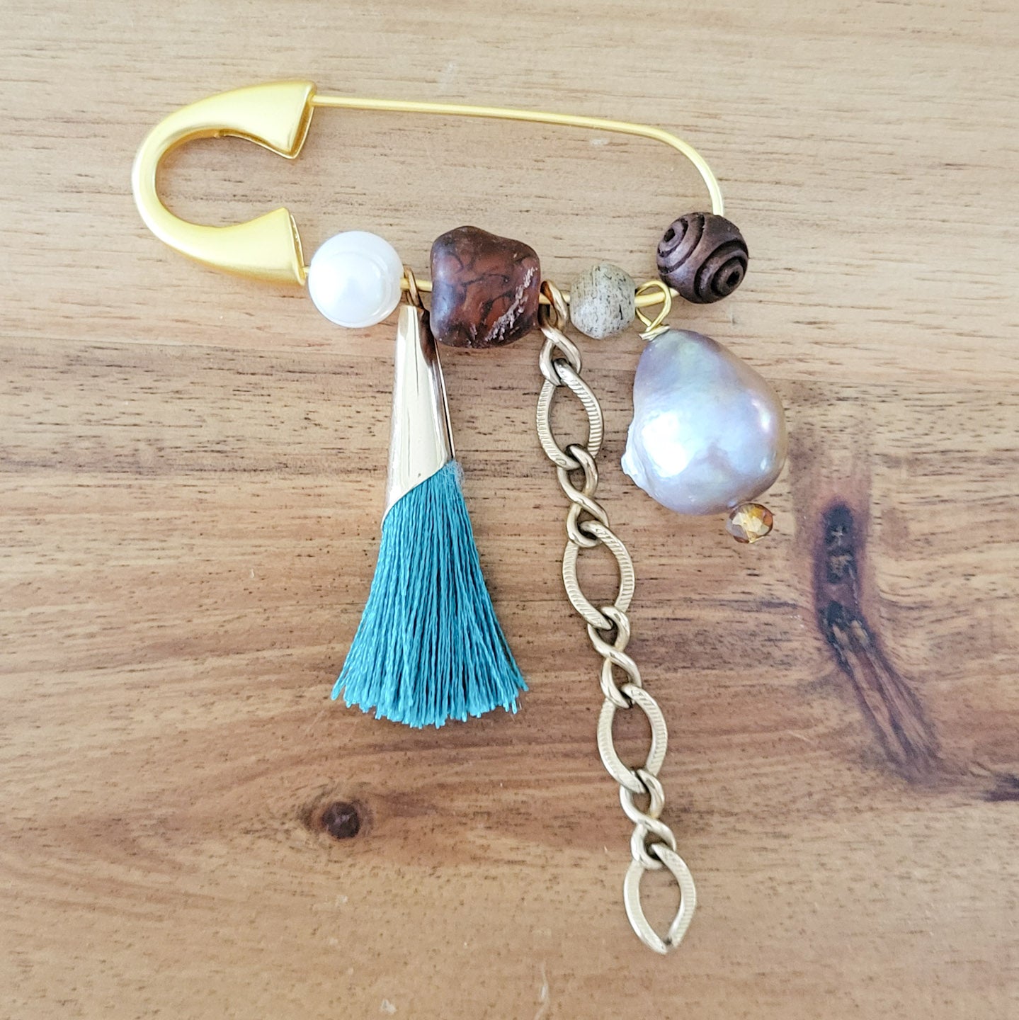 gold safety pin w variety of charms and freshwater pearls