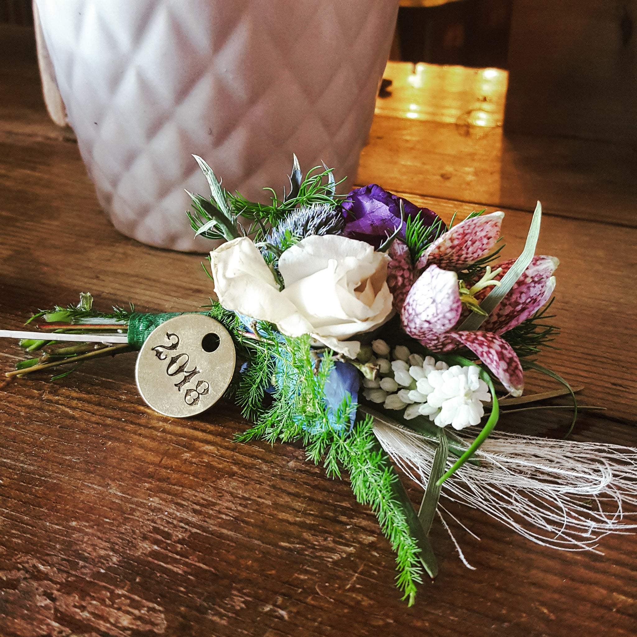 vintage hand stamped wedding date on brass tag on a boutonniere