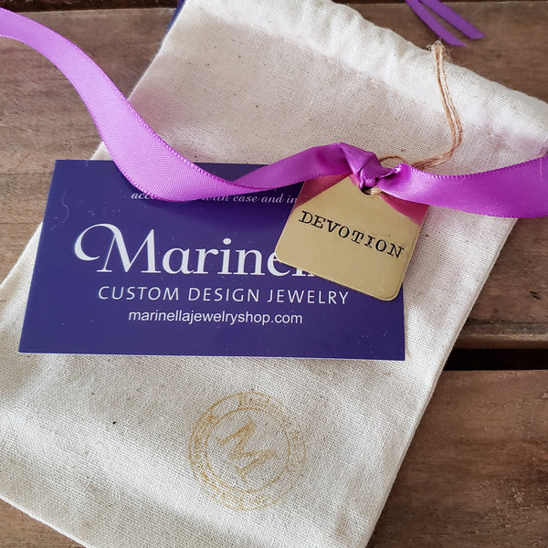 vintage hand stamped messages on brass tags tied on a purple ribbon